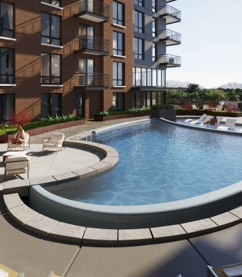 Montaire Student Living Apartments Modern apartment pool area with lounge chairs and people relaxing beside a curved pool on a sunny day.