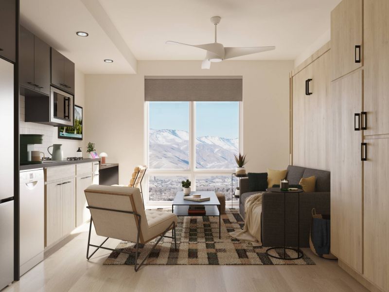 Montaire Student Living Apartments Modern studio apartment with light wood furniture, a gray sofa, armchair, large window, and mountain view.
