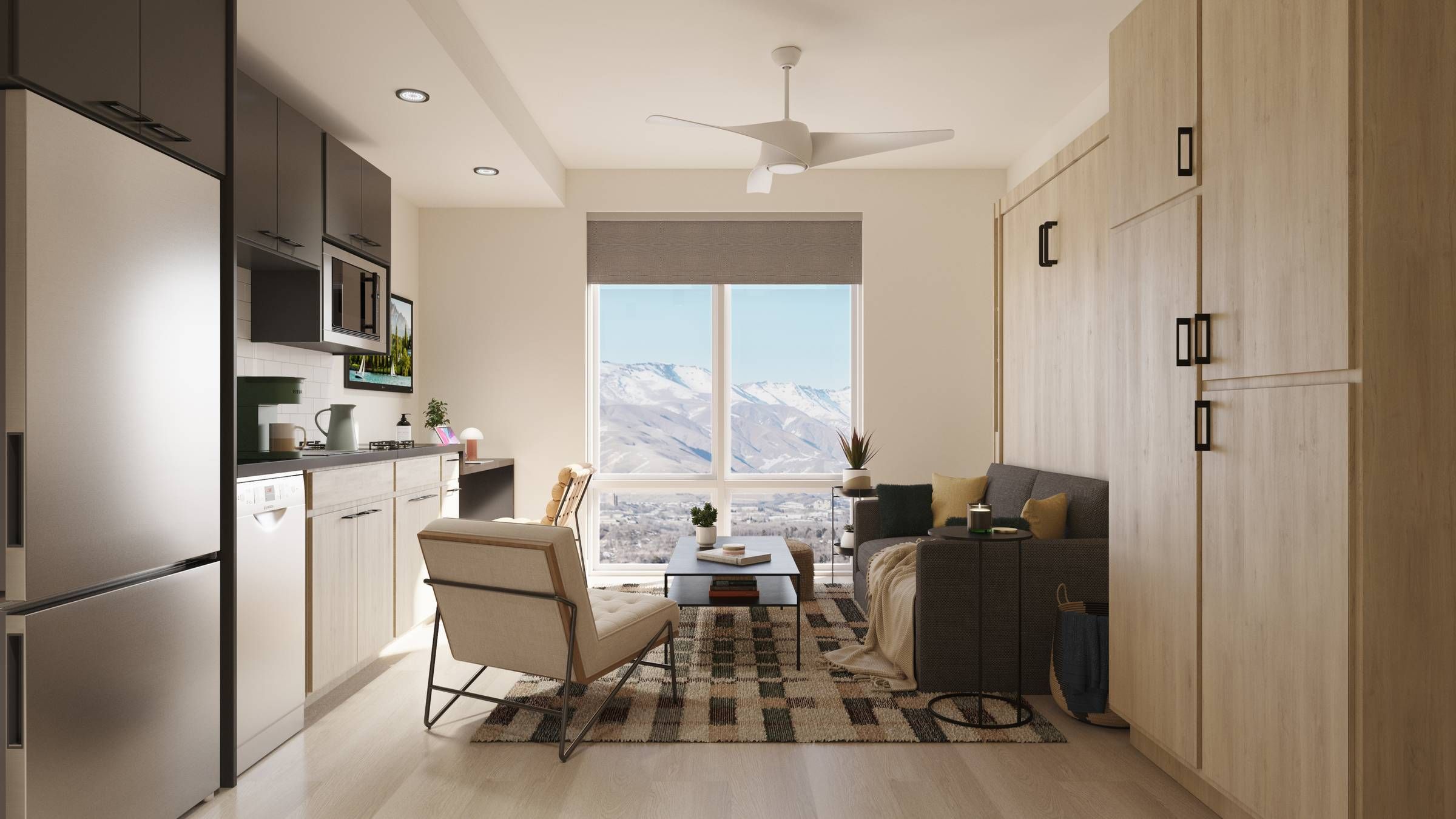 Montaire Student Living Apartments Modern studio apartment with light wood furniture, a gray sofa, armchair, large window, and mountain view.